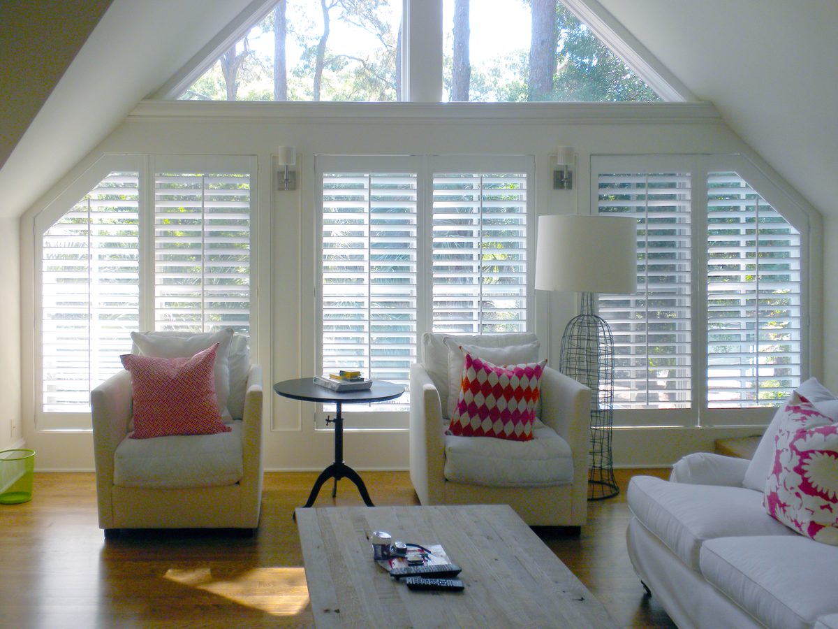 Custom white plantation shutters on an angled living room window
